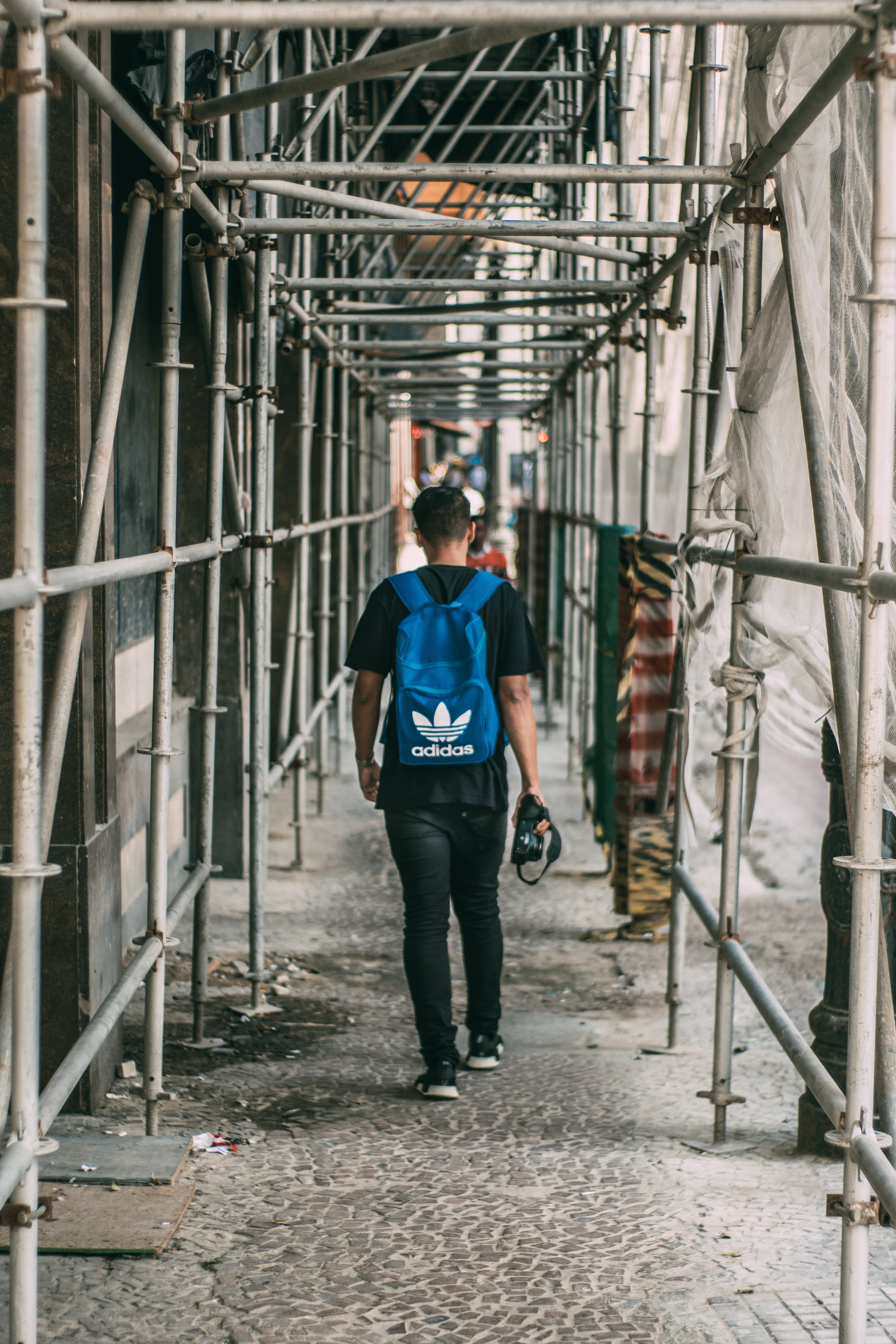 man standing beside pipes by Kaique Rocha
